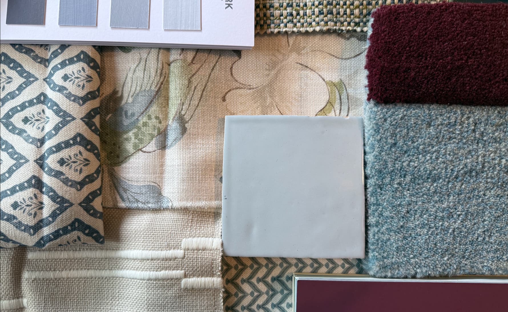 Interior design materials flat lay — fabric, paint, and carpet samples